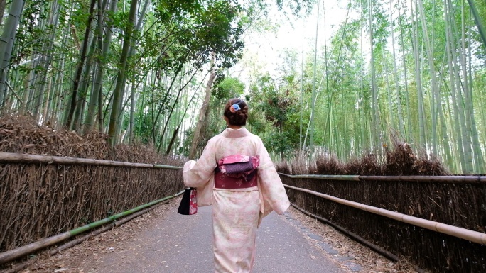 一名身穿和服的女子走过荒山竹林