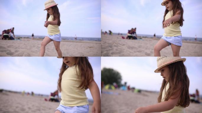 戴帽子的可爱小孩在沙滩上散步
