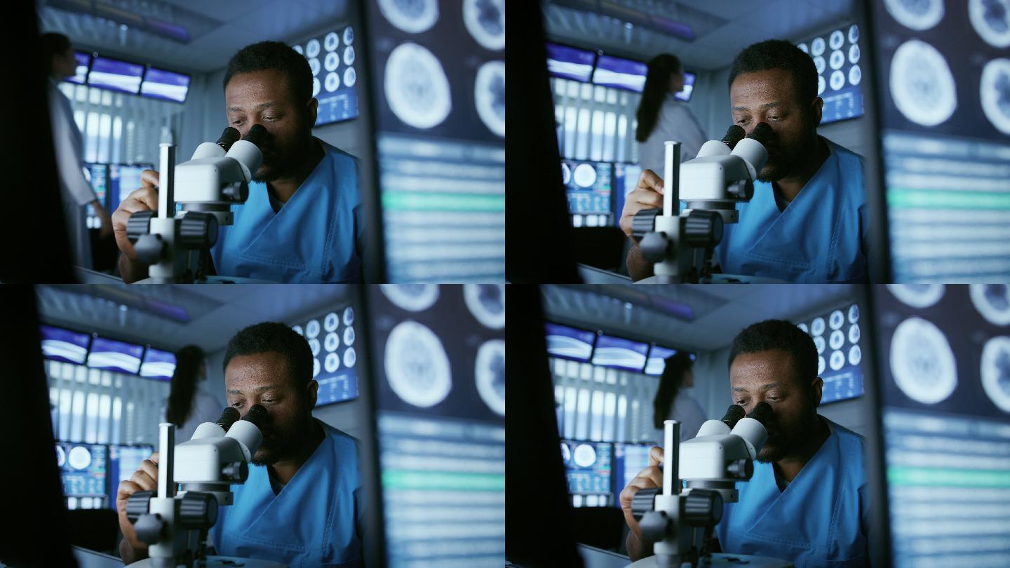医学研究科学家在实验室的显微镜下观察。