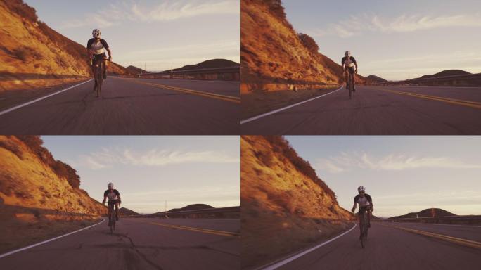 年轻健康的男子骑着公路自行车在夕阳下山