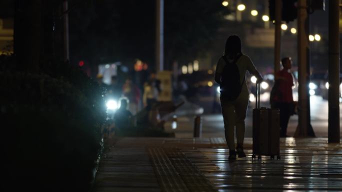 女孩拖行李箱城市深夜下班行人背影，