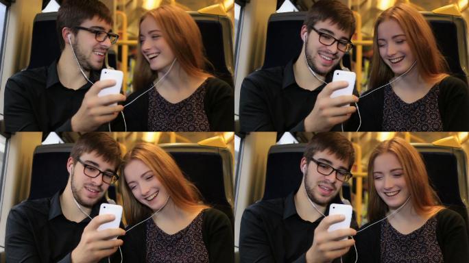 一对年轻夫妇在火车上听音乐。