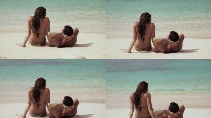 一对年轻夫妇在热带海滩上放松
