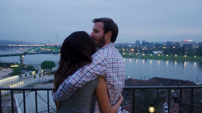 情侣在浪漫约会时在楼顶接吻