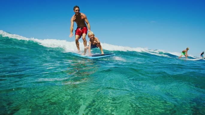 在冲浪的父子亲子互动活动时光海水海浪