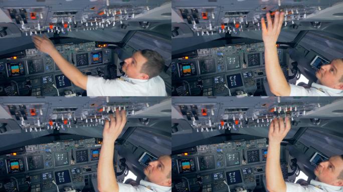飞行员在飞行前正在切换驾驶舱上部的按钮