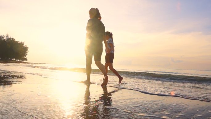日落时分母女在海滩散步