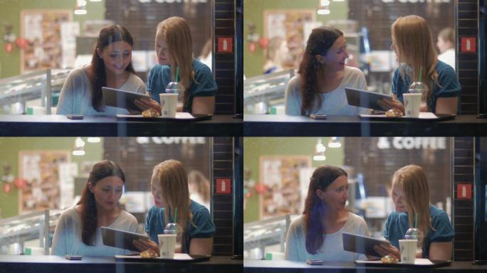 两个女性朋友在咖啡馆见面。外面在下雨