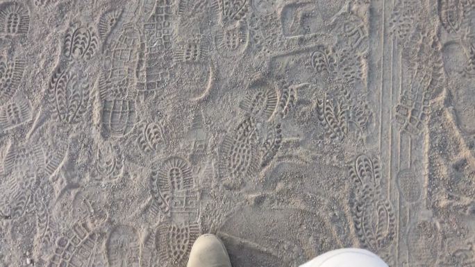 穿着靴子在沙漠沙滩上行走的人