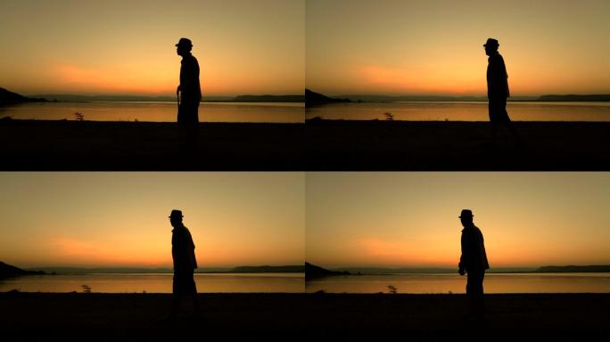 老年男性在湖边夕阳下手杖散步