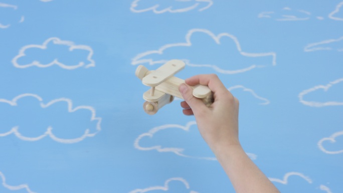 在蓝色背景上玩木制玩具飞机