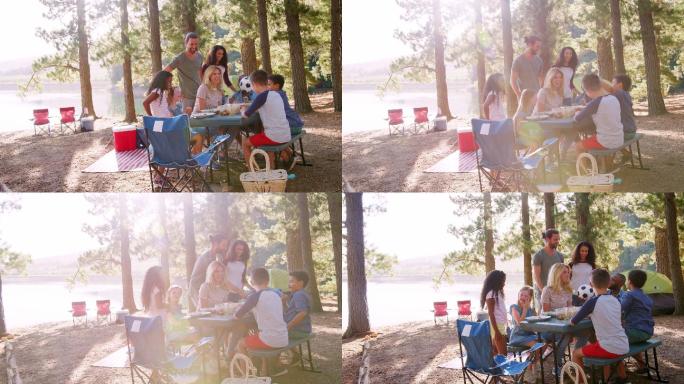 一家人和朋友在湖边露营时野餐