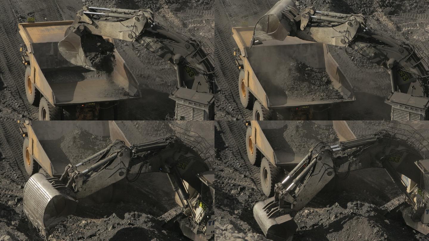 一辆运土车将泥土装载到一辆煤矿卡车上。