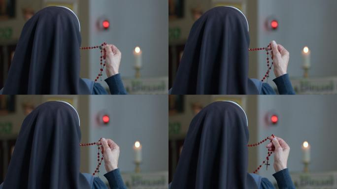 从一个持念珠祈祷的宗教修女的背后看。