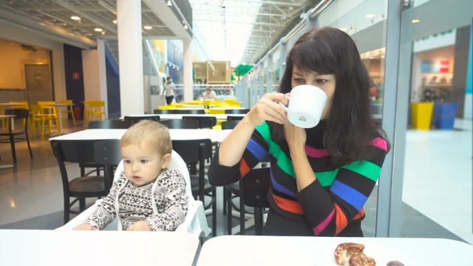 年轻的母亲带着儿子在咖啡馆吃早餐