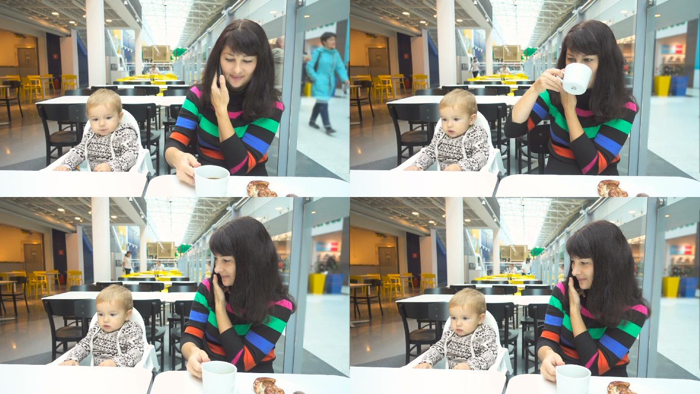 年轻的母亲带着儿子在咖啡馆吃早餐