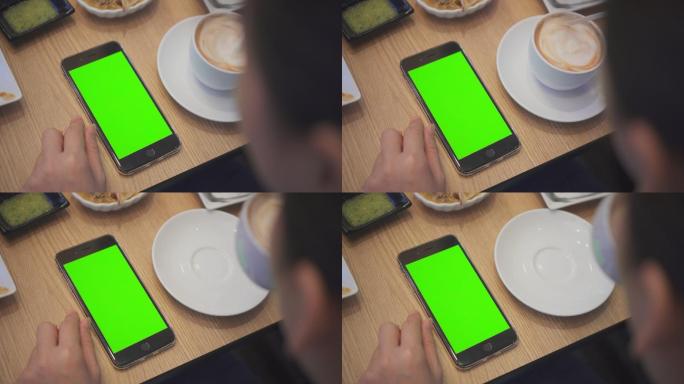 在餐厅使用绿色屏幕的智能手机