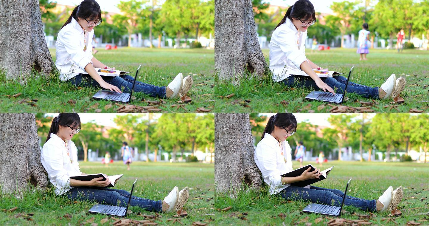 女孩在公园树下看书、用笔记本电脑打字