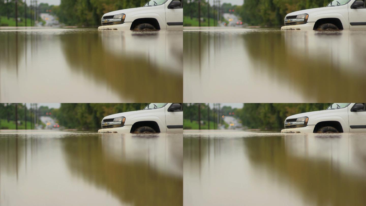 一辆白色汽车被困在一大片被洪水淹没的地区