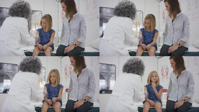 小学生坐在检查台上，医生检查她的血压