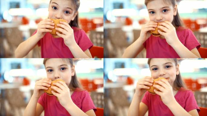 吃汉堡的小女孩。