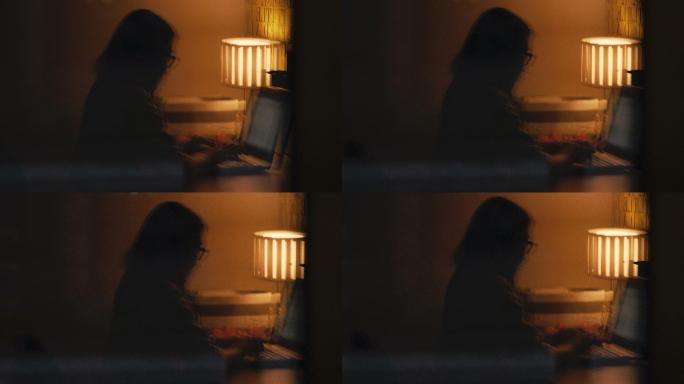 女性在家里使用笔记本电脑工作到深夜