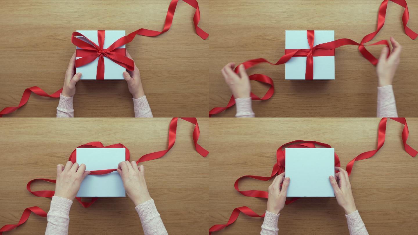 女子打开礼品盒上的红丝带