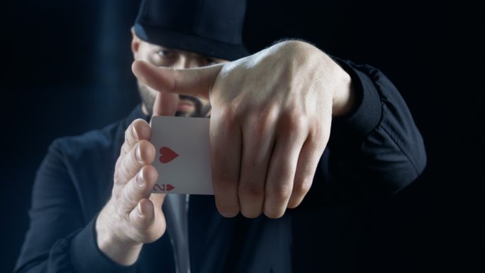 职业街头魔术师表演扑克牌消失魔术。