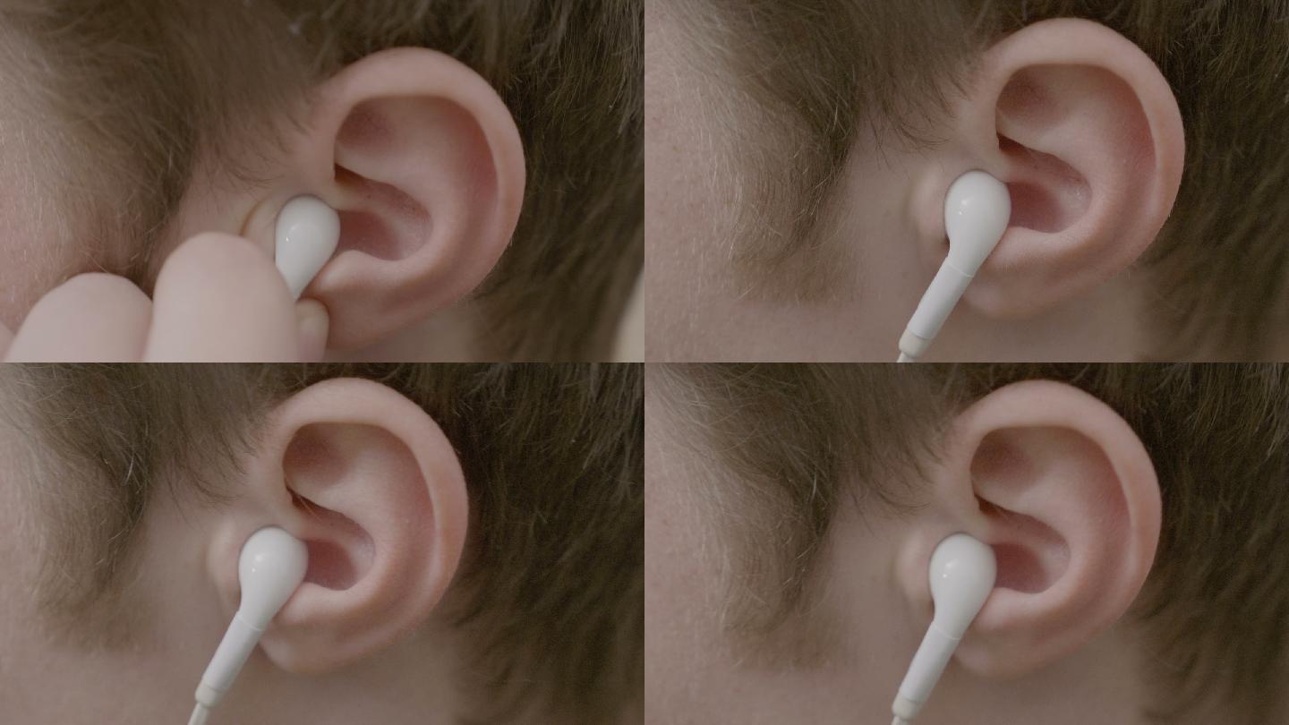 男性耳朵的特写镜头戴着耳机听音乐