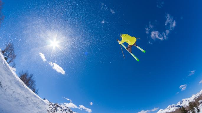 滑雪运动员在雪地公园表演跳跃特技