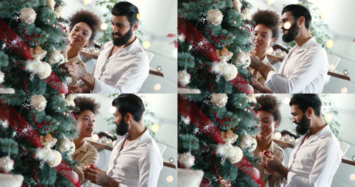 一对年轻夫妇正在装饰圣诞树