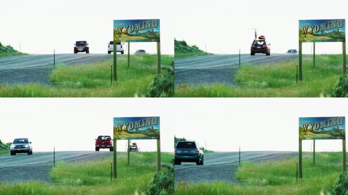 车辆驶过怀俄明州边界上的怀俄明州线标志