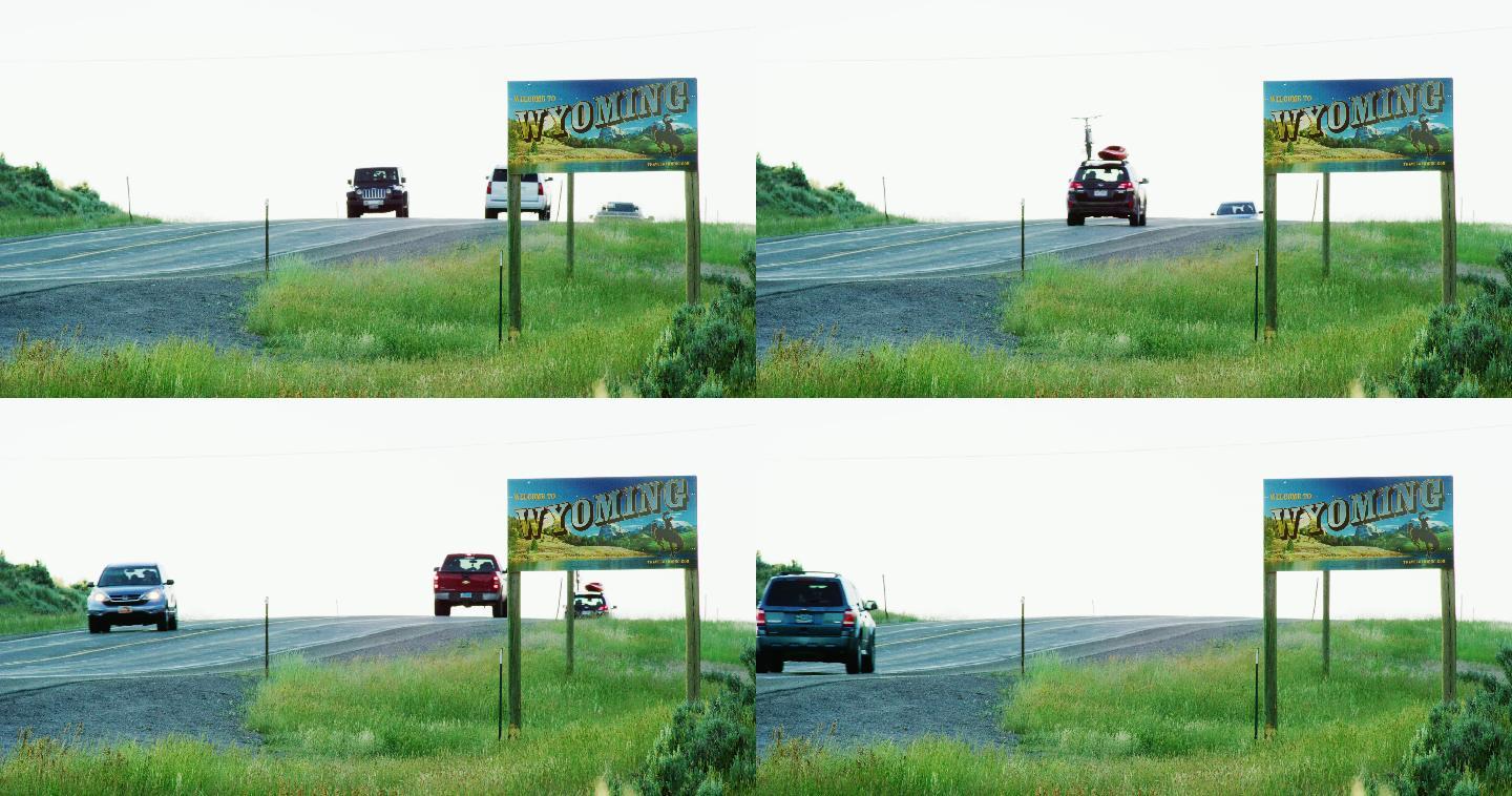 车辆驶过怀俄明州边界上的怀俄明州线标志