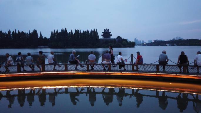人们坐在襄阳古城护城河木栈道上乘凉