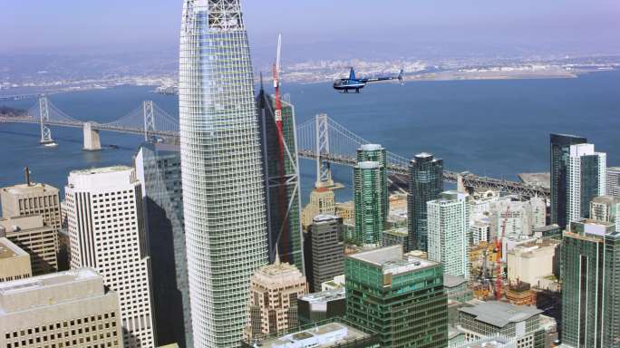 空中直升机在旧金山摩天大楼上空飞行