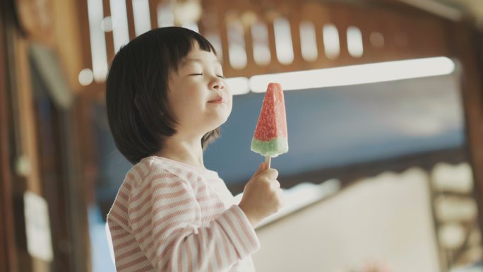 可爱的女孩正在吃西瓜形状的冰激凌
