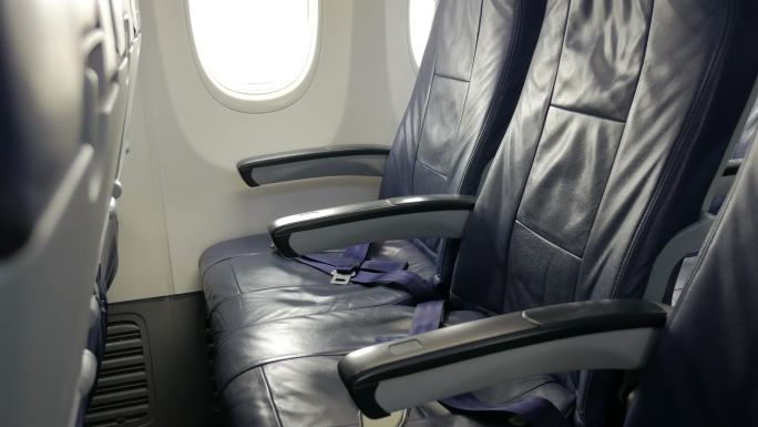 带有蓝色乘客座椅的商用飞机客舱内部。