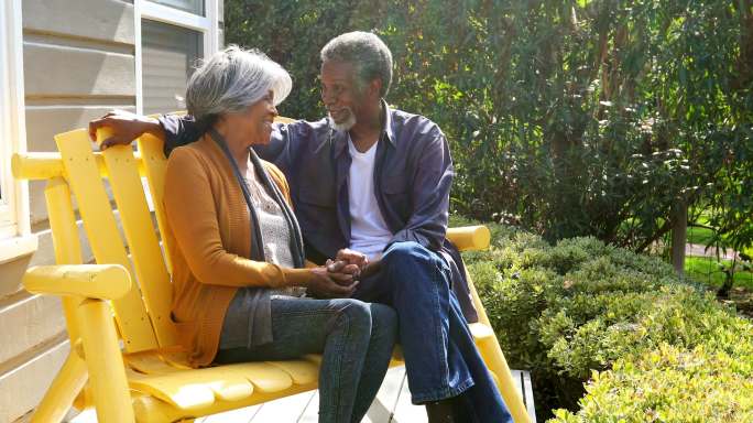 老年夫妇在阳光下坐在家门口聊天