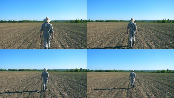 一个年轻男农民正在田地里行走查看