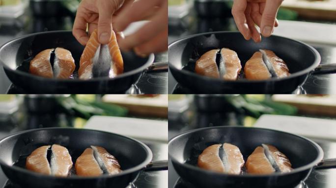 把一块红鱼片放在热锅上的特写镜头