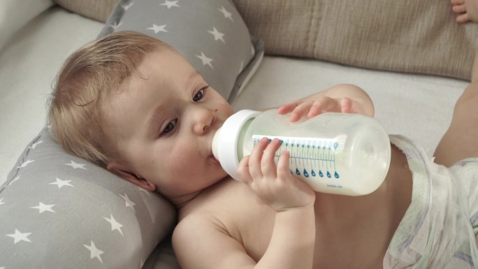 婴儿在喝奶瓶里的牛奶