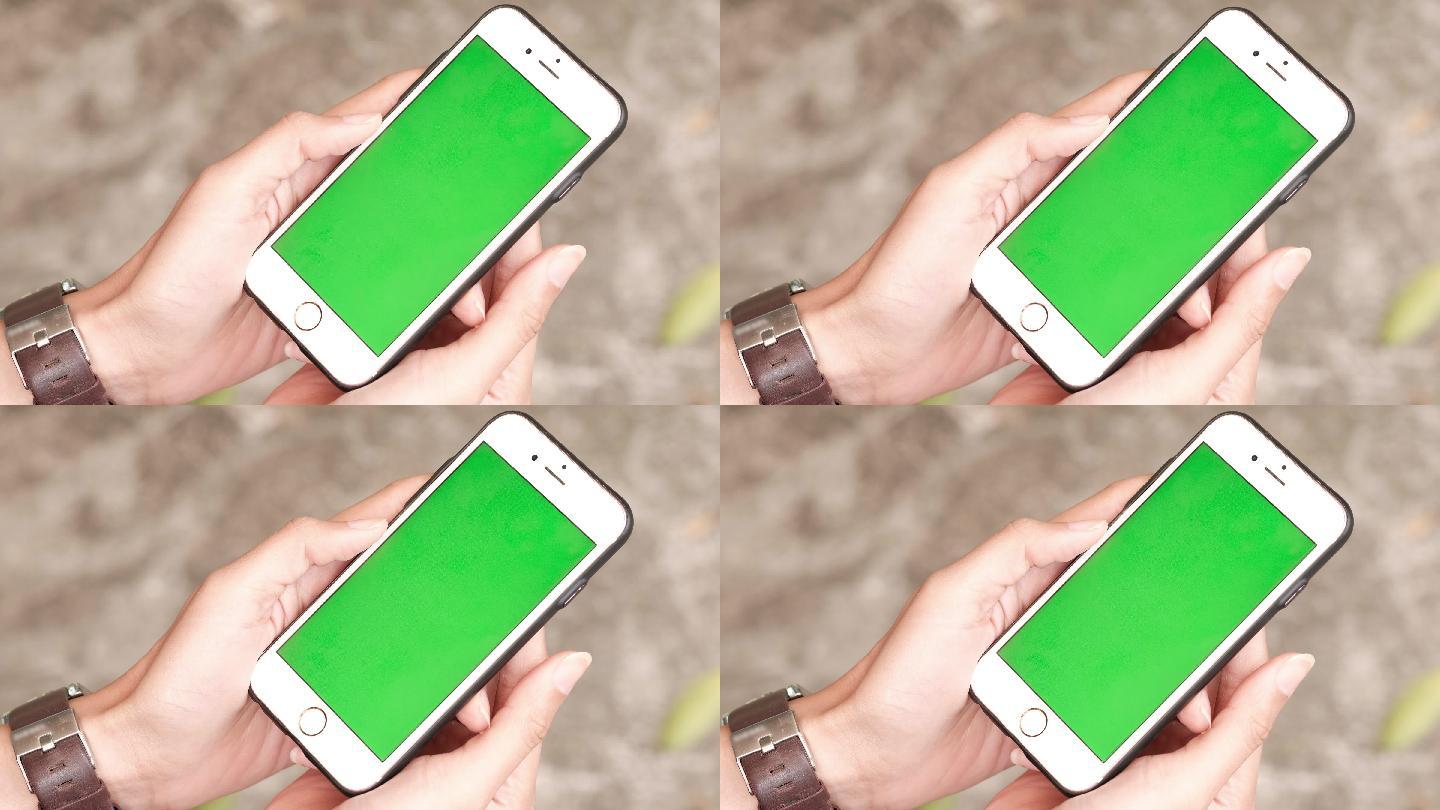 一个女人拿着一个绿色的智能手机