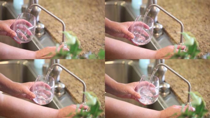 一位妇女把新鲜的饮用水倒进透明的玻璃杯里