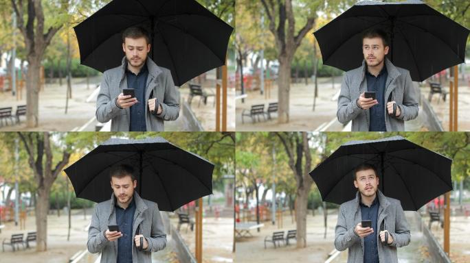 沮丧的男人在雨天查看手机上的天气应用程序