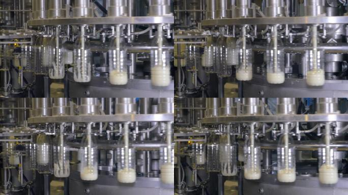 在牛奶生产厂的工业设备上把牛奶倒进瓶子里