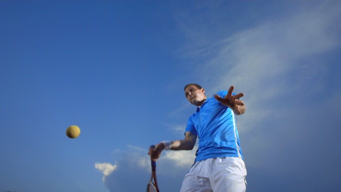 职业网球运动员在户外训练时用网球拍击球