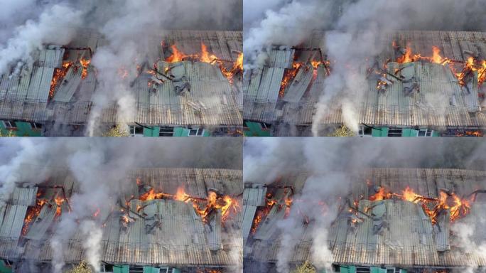 一栋居民楼的屋顶着火，浓烟从火中冒出来