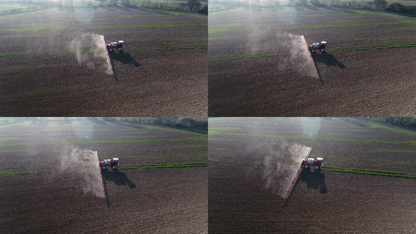拖拉机在耕地上喷洒草甘膦除草剂