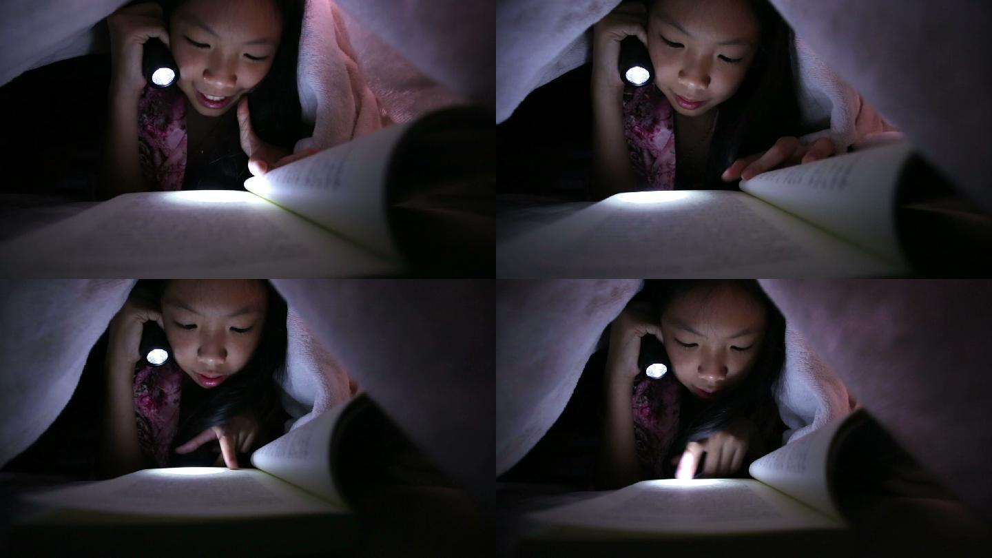 小女孩在床上用手电筒看书