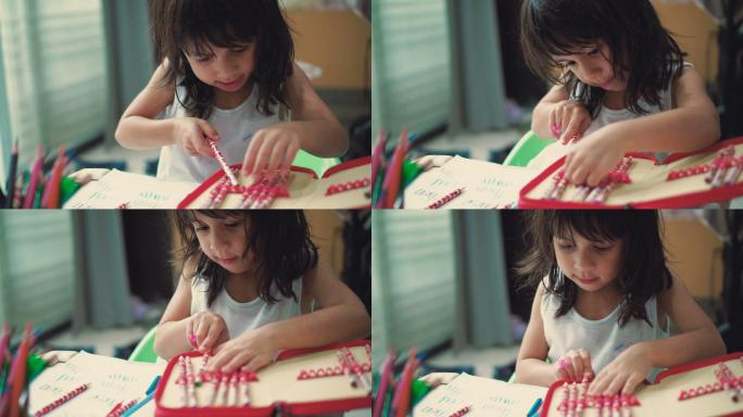 一个女孩在客厅的桌子上挑选铅笔做作业